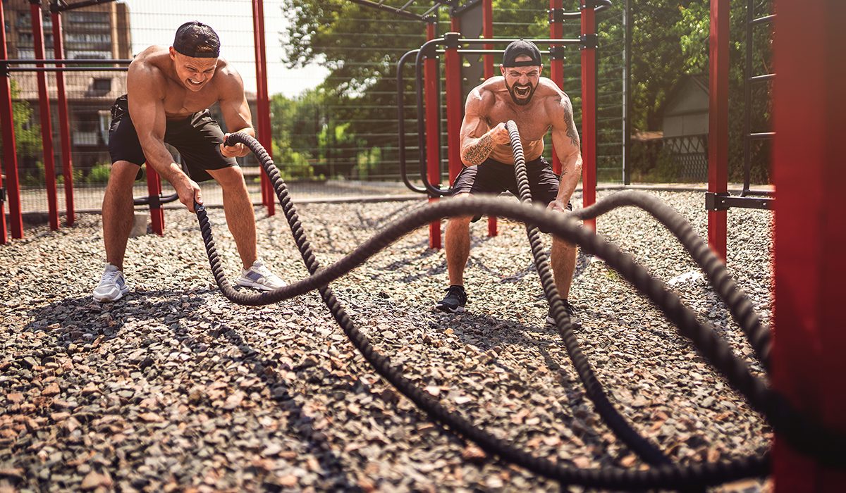 Men work hard with rope at street gym yard. Strength and motivation. Outdoor workout. fitness, sport, exercising, training and lifestyle concept .